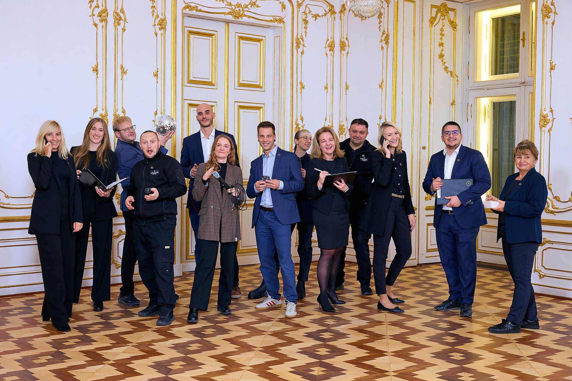 Team von Schönbrunn Meetings und Events steht in einer Gruppe und lächelt in die Kamera