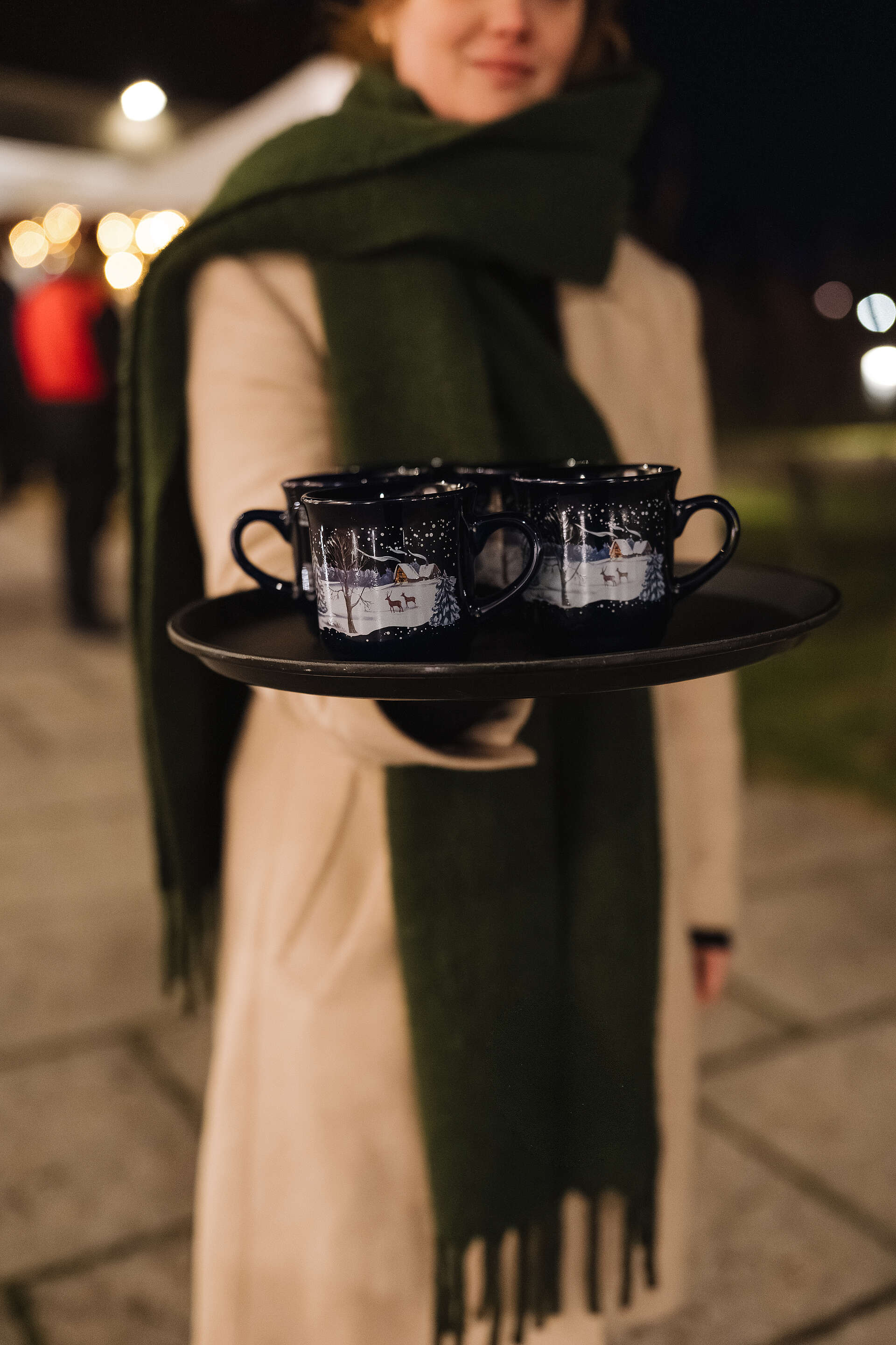 Kellnerin die Tassen mit Punsch serviert 