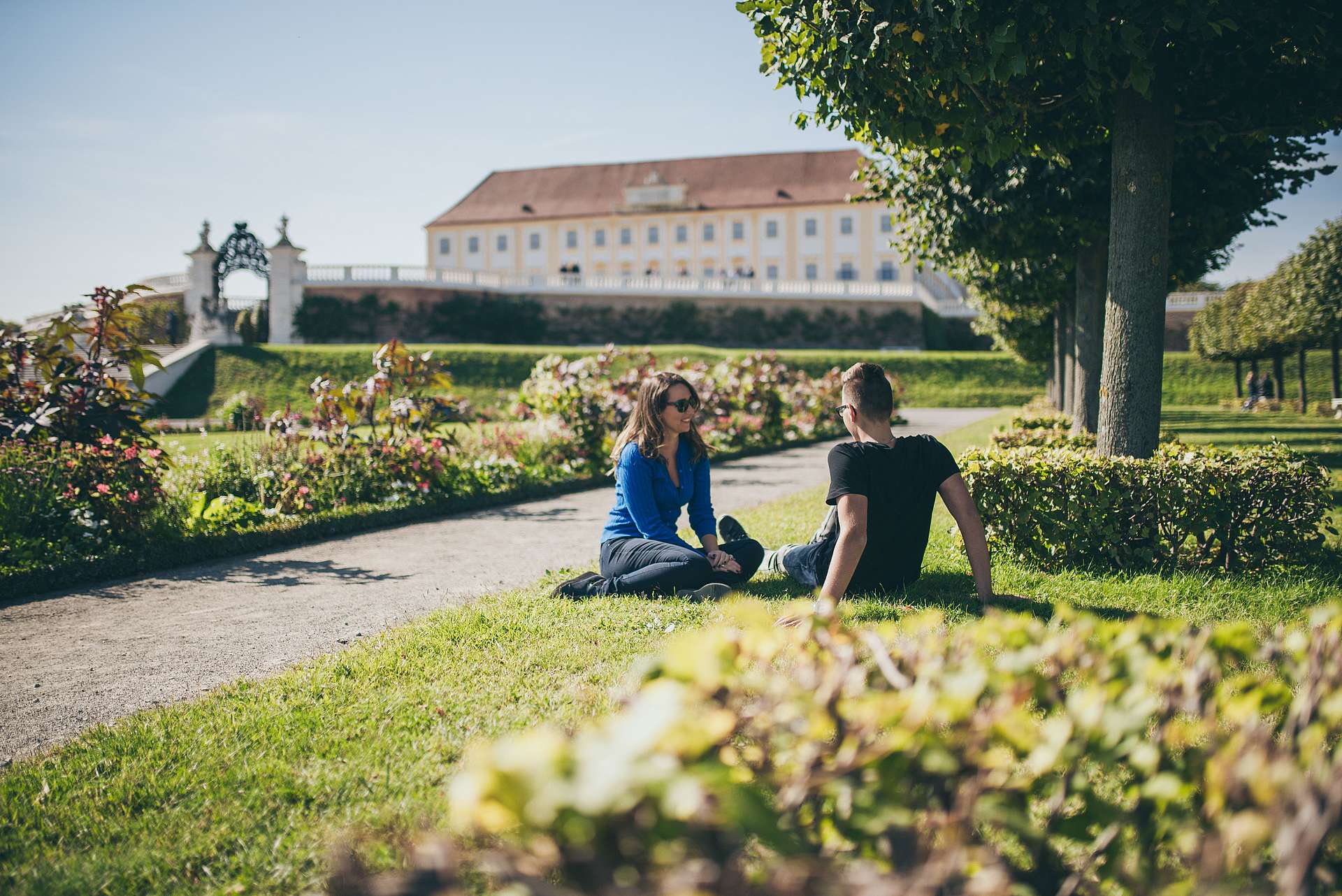 Ein Paar sitzt im Garten vor Schloss Hof